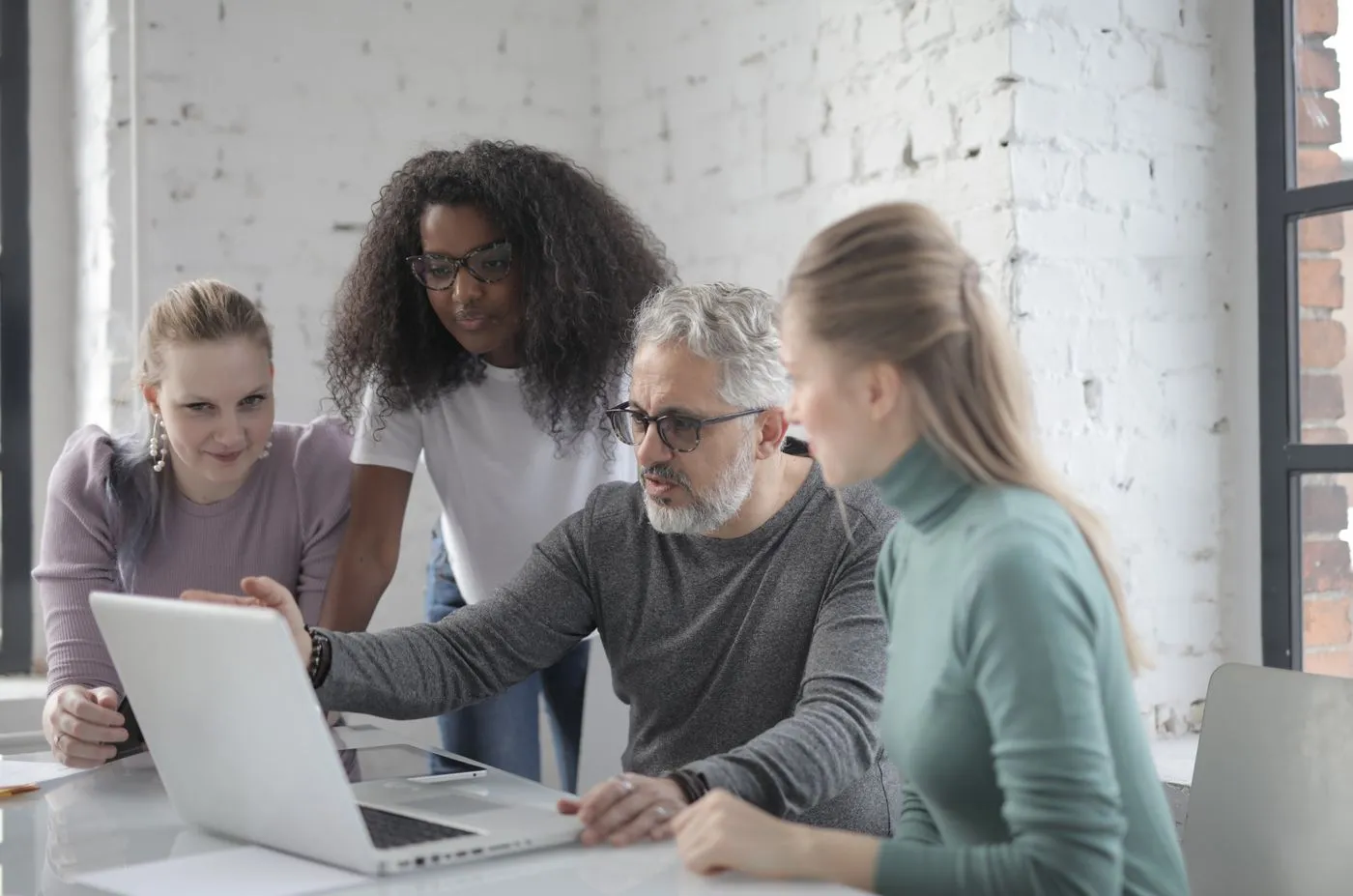 A Brydge Academy instructor walking a small team through a hands-on lesson on a laptop