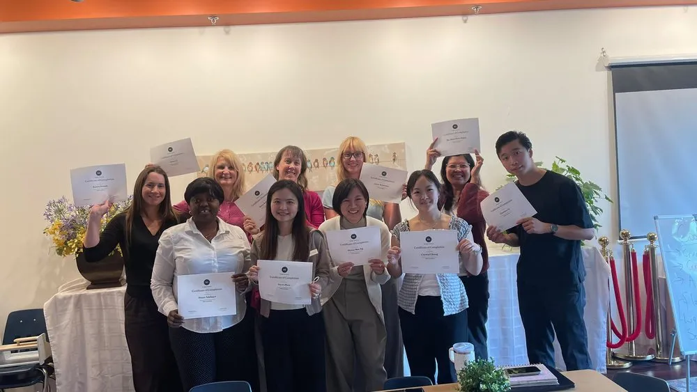 A group of participants holding their Brydge Academy certificates of completion after an on-site session