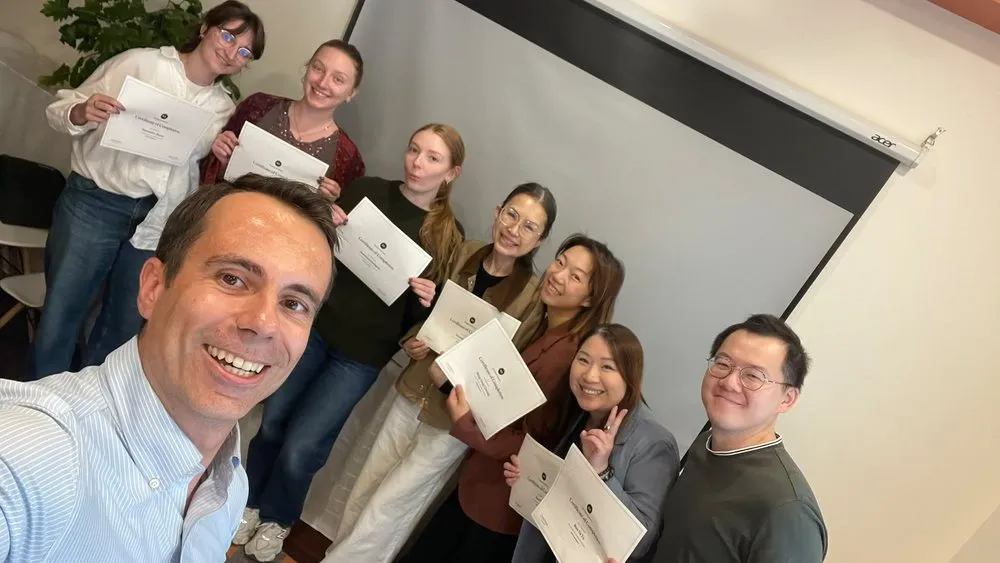 Thomas Mouquot, lead instructor, with participants holding their certificates after a session